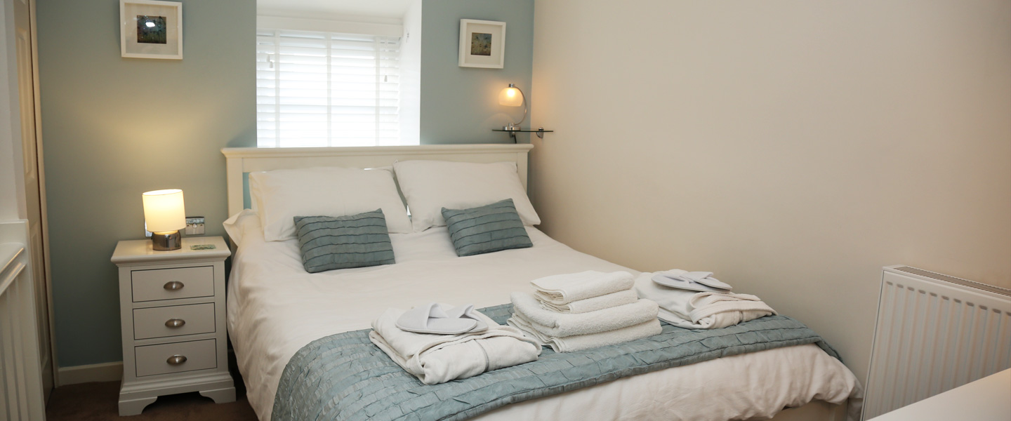 Kirrin Cottage master bedroom king size bed, ensuite shower, basin and toilet